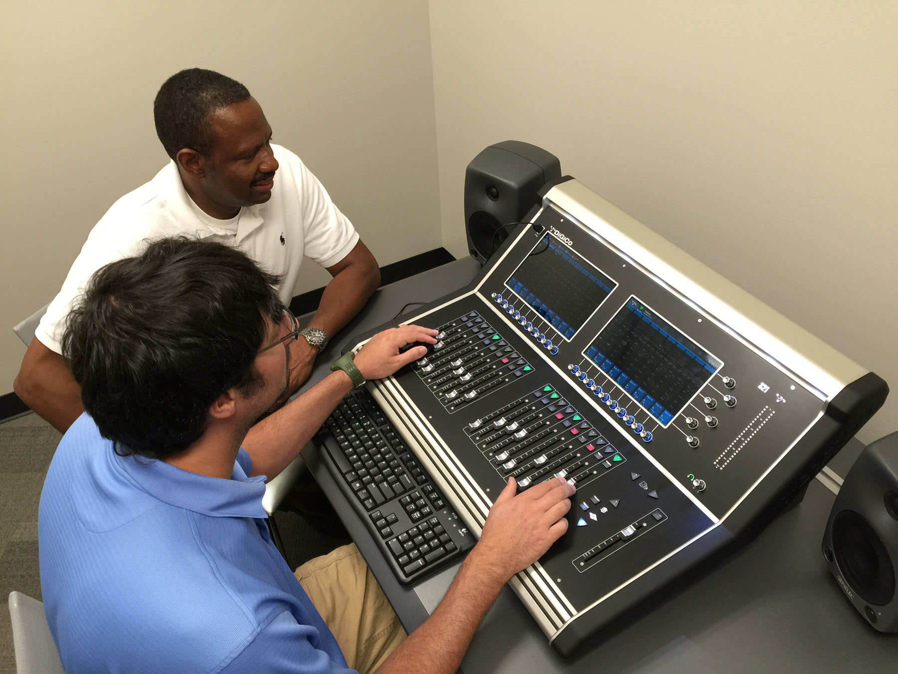 Mississippi State University’s Bennie Ashford (white shirt) and Jonathan Ashley at the DiGiCo S21 console in Davis Wade Stadium’s new production facility.