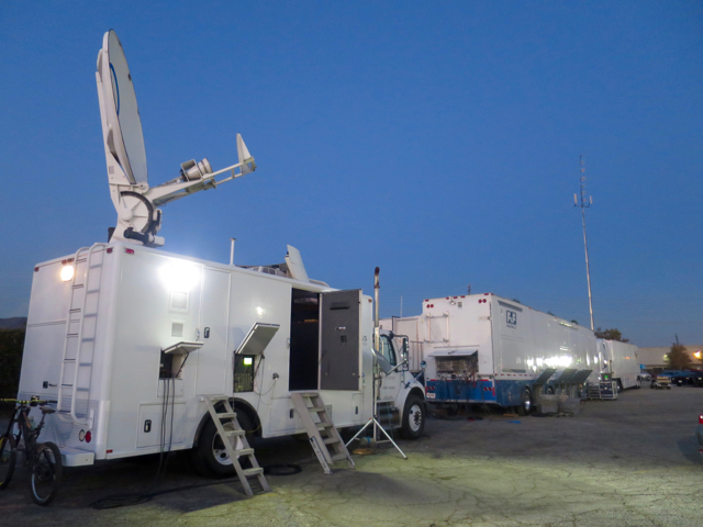 The NHRA truck compound features an F&F truck, a BSI truck, an Encompass Digital satellite uplink, and a Screenworks truck.